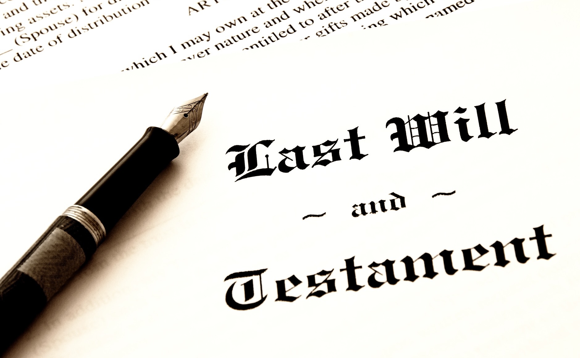 Photo of the header of a last will and testament with a pen sitting on it